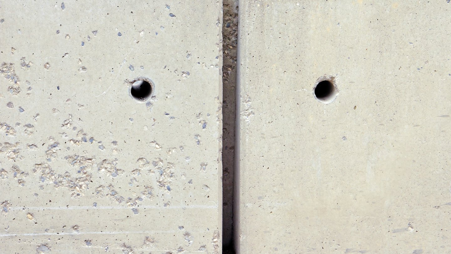Two textured concrete slabs separated by a vertical seam.